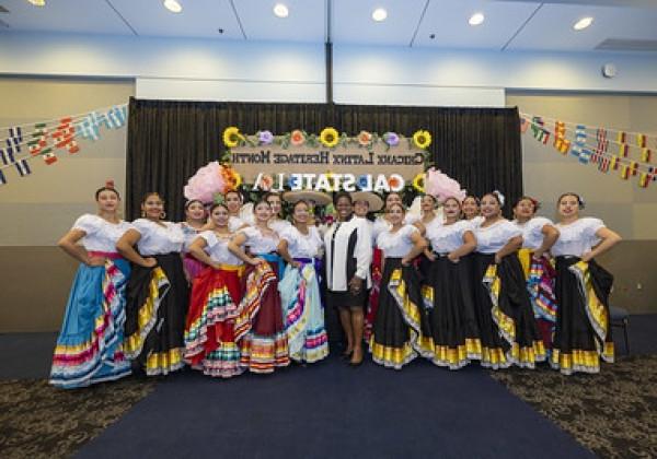 President and performers posing for photo at Chicanx Latinx University Alumni Network mixer