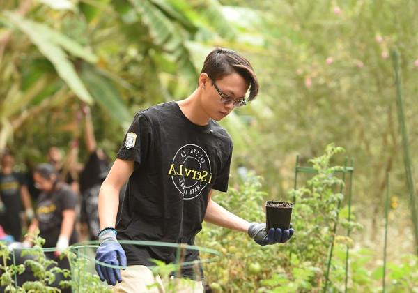 Student holding a small potted plant.